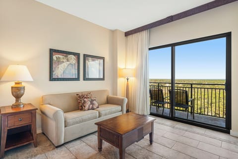 Relax in this cozy living room with balcony views of the surrounding landscape.