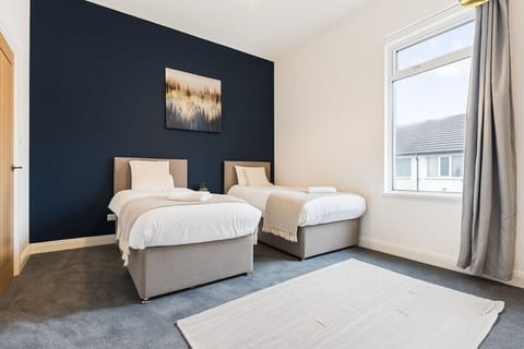 Bedroom one features twin beds with fresh linen and towels provided