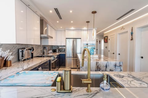 Sleek kitchen with marble countertops, high-end appliances, and elegant lighting