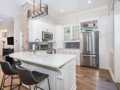 The open bar counter connects the kitchen to the dining/living area, offering a perfect spot for casual dining or entertaining. With sleek stools and ample space, it enhances the flow and social vibe of the home.