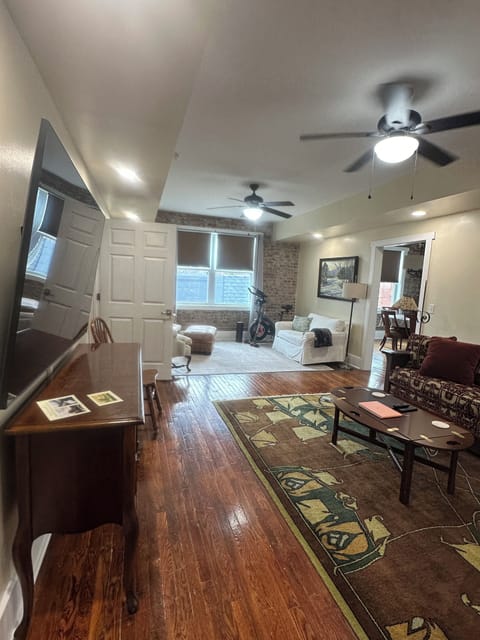 View from hallway door of living area with sofa/bed and TV/dresser.
