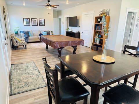 Dining and living rooms. Full sized pool table, smart TV and queen soda bed