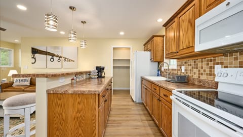 The upper level Kitchen includes a Keurig coffee maker that will brew a whole pot using coffee filters or one cup at time using coffee pods. There is a full size electric range and microwave. There is a large walk-in pantry next to the Refrigerator.