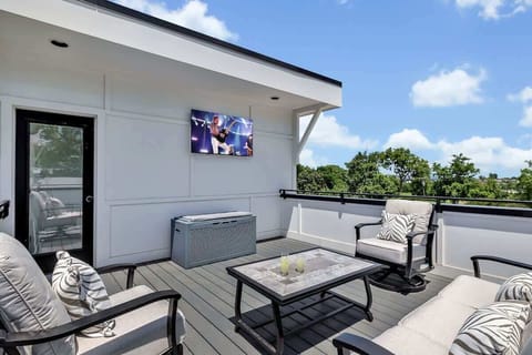 4th Floor: Private rooftop patio featuring outdoor furnishings for lounging and a Smart TV for entertainment surrounded by beautiful neighborhood views.