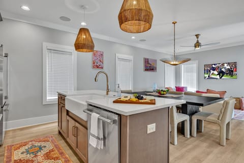2nd Floor: Fully equipped kitchen stocked with all culinary essentials featuring stainless-steel appliances and a kitchen island offering ample counter space and bar seating.