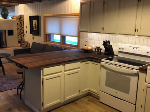 Circle 'round the kitchen bar with stools and enjoy a view of the fireplace & TV