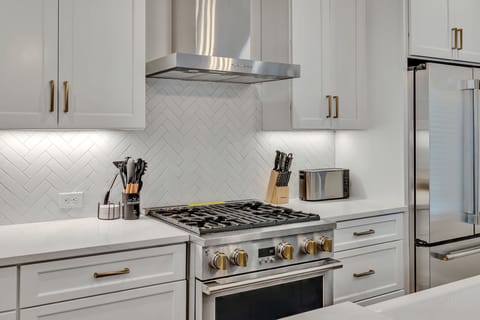 2nd Floor: Fully equipped kitchen stocked with all culinary essentials featuring Monogram stainless-steel appliances, a large kitchen island offering bar seating.