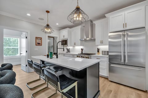 2nd Floor: Fully equipped kitchen stocked with all culinary essentials featuring Monogram stainless-steel appliances, a large kitchen island offering bar seating.