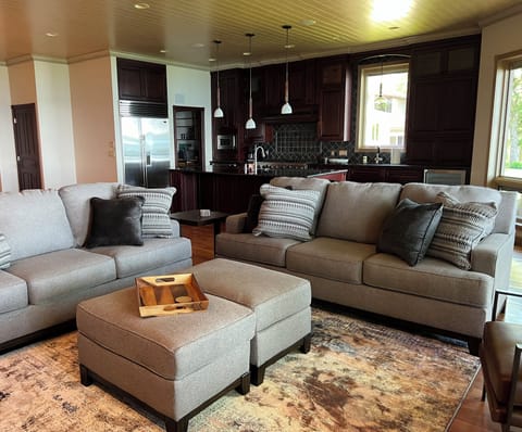 Great room adjacent to kitchen with two large sofas and big lake views
