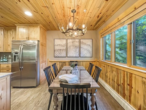The dining table is conveniently located off the kitchen and boasts natural light from the windows.