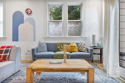 The living room is bright and spacious, featuring comfortable seating perfect for relaxing or entertaining. Large windows flood the space with natural light, creating a welcoming atmosphere for your stay☀️

