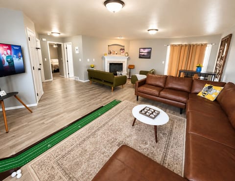 Spacious downstairs with comfortable couches, putting green, games and TV