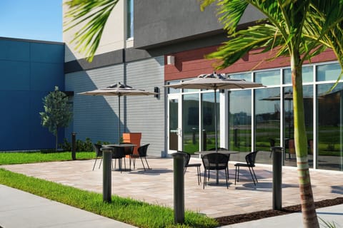 Unwind on the modern patio with umbrellas and open skies.