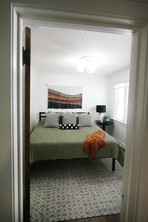 The first floor bedroom has a king bed, closet with hangers, and luggage rack.