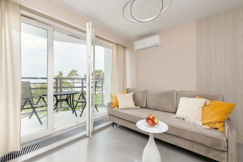 Bright and spacious living area opening onto a furnished balcony with sea views.

