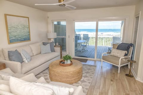 Coastal living room flows into dining, with ocean views.
