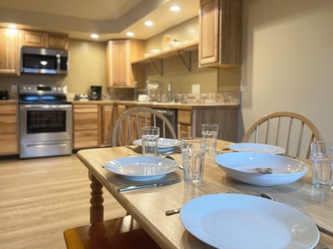 Family style wood table with chairs and a bench. Beautiful dining area, open kitchen floor plan.