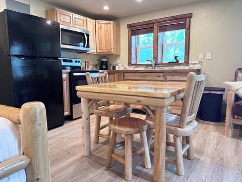 Log wood dining room table, full sized fridge, gas stove, microwave.