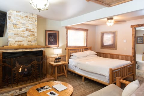 Sitting area with wood coffee table, large tv and a cozy gas fireplace.