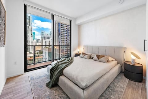 Relax in a designer bedroom framed by downtown skyline views.
