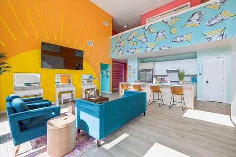 Bright open-concept living space with a Smart TV, queen Murphy beds, and a modern kitchen with bar seating—plus a private balcony right off the room for fresh air + skyline vibes!