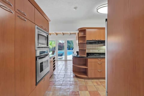 “Cook and gather in this modern Airbnb kitchen with stainless appliances, poolside views, and tropical charm—perfect vacation rental for family meals, relaxation, and unforgettable stays.”
