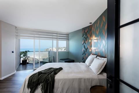 Beautiful & spacious bedroom featuring a stunning accent wall with wooden elements and unique lighting that together create a cozy atmosphere. Upon request, we can prepare an additional comfortable single bed in the bedroom.