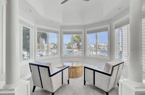 Your elegant seating nook offers panoramic marina views through floor-to-ceiling windows, perfect for morning coffee or evening relaxation.