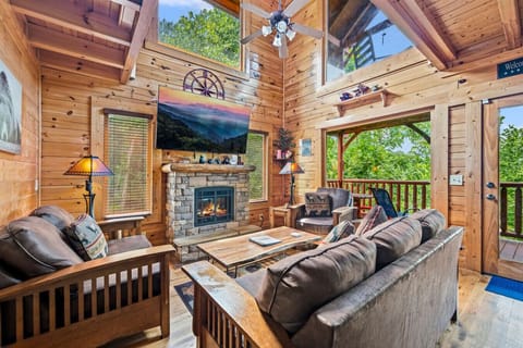 Beautiful living room with stone fireplace, large Smart TV and plenty of comfortable seating.