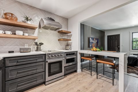 Fully equipped kitchen boasting stainless steel appliances and stocked with all culinary essentials.