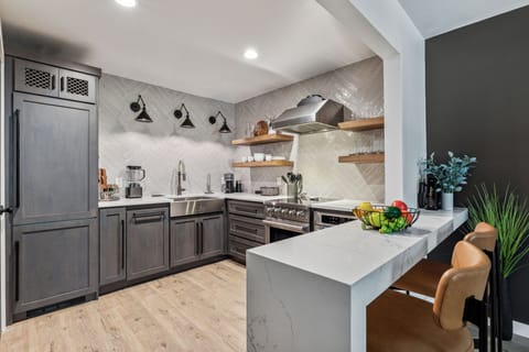Fully equipped kitchen boasting stainless steel appliances and stocked with all culinary essentials.