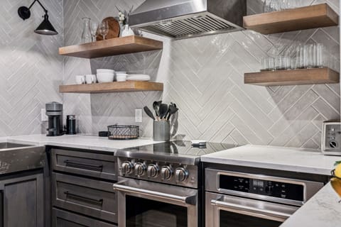 Fully equipped kitchen boasting stainless steel appliances and stocked with all culinary essentials.