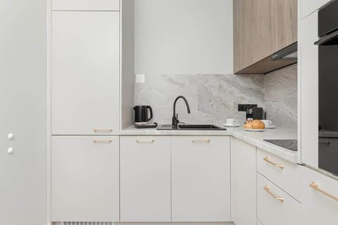 A modern white kitchen with clean lines in a bright interior.

