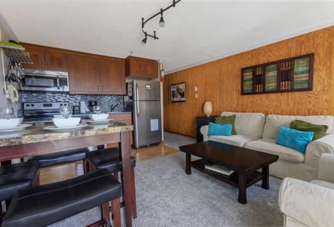 The cozy living room has a table that sits four people and a sleeper couch for additional sleeping capacity.