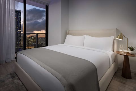Wake up to soft sunrise hues over the skyline.