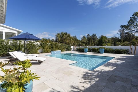 Dive into your private oasis with this sparkling pool surrounded by comfortable loungers and tropical landscaping for ultimate relaxation.