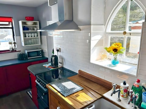 Kitchen with sink, cooker, kettle, toaster, microwave and arch window