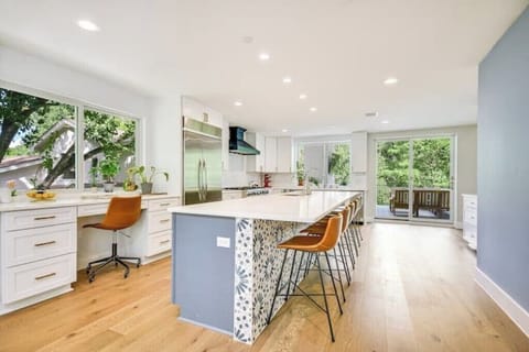 Kitchen w/double sided door fridge and attached desk w/comfy chair.