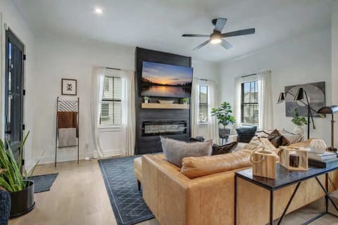 Relaxation awaits in this bright living area with chic leather furniture and a modern fireplace.