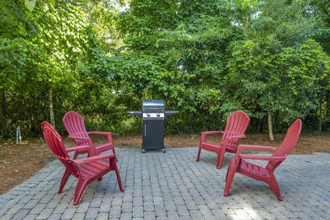 Outdoor driveway patio with seating and a BBQ grill, perfect for outdoor dining and relaxation.