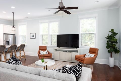 Bright and inviting living room with large TV and comfy seating for a relaxing stay.