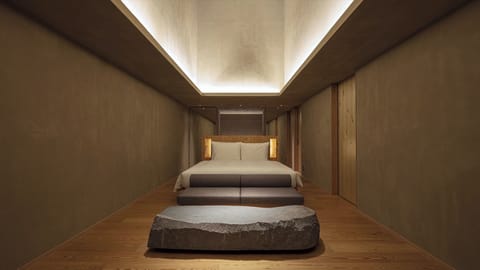 [SOKI Suite] 66m² / bed width 1,800mm. Equipped with a sofa and a stone table.