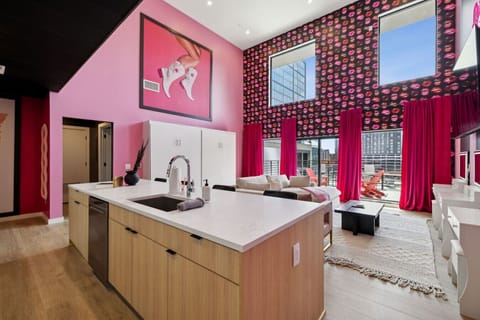 Bright, glam open-concept space with an oversized island, bold décor, and huge windows for natural light—perfect for pregame snacks, selfies, and lounging before a night out in Nashville!