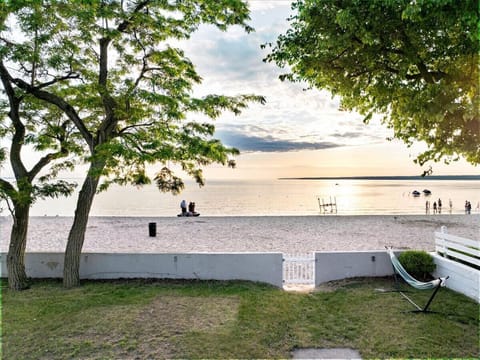 Backyard photo revealing a pathway to the beach, surrounded by lush greenery and serene ocean views.