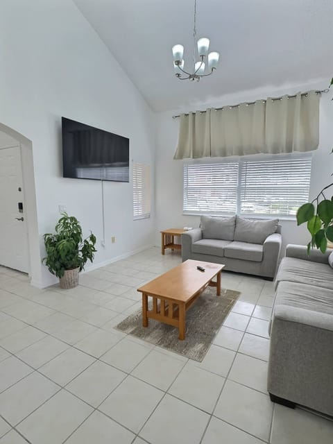 Step into a bright living room featuring ample natural light streaming through elegant window treatments. The cozy gray sofa invites relaxation, while the wooden coffee table adds a warm, homey touch to this inviting space.