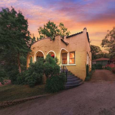 Charming 1925 Spanish Revival home with glowing arches, cozy porch & private drive.