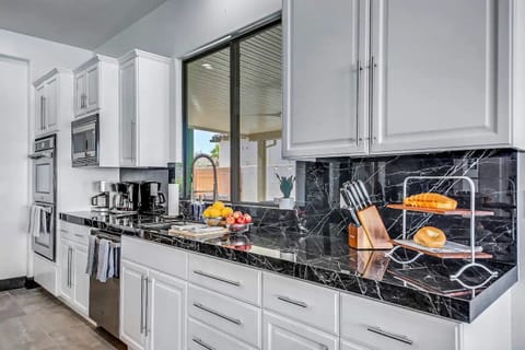 Every detail is designed with care — from the striking black marble countertops to the fully stocked essentials like a knife block, toaster, coffee station, and modern appliances. Whether you're whipping up breakfast or prepping a full dinner, this kitchen has everything you need in style.