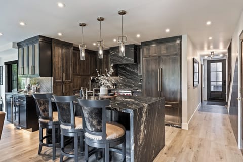 - Cook in a gourmet kitchen with sleek black marble counters  
- Gather at the island with seating for meals or casual drinks  
- Enjoy modern lighting and custom cabinetry with premium finish