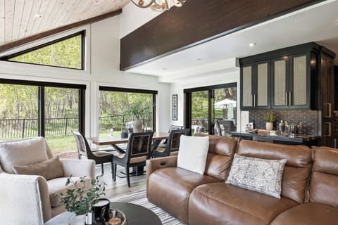 - Share meals at the dining table with forest views all around  
- Large windows fill the space with natural light and scenery  
- Gather in comfort next to the living room and open kitchen