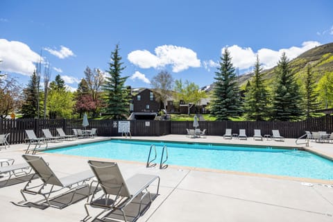 - Refresh with a dip in the outdoor pool surrounded by mountain views  
- Lounge on sunbeds under the clear blue sky and pine trees  
- Relax after exploring nearby trails and scenic landscapes